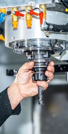 Operator changing tool in CNC milling machine for precision metalworking